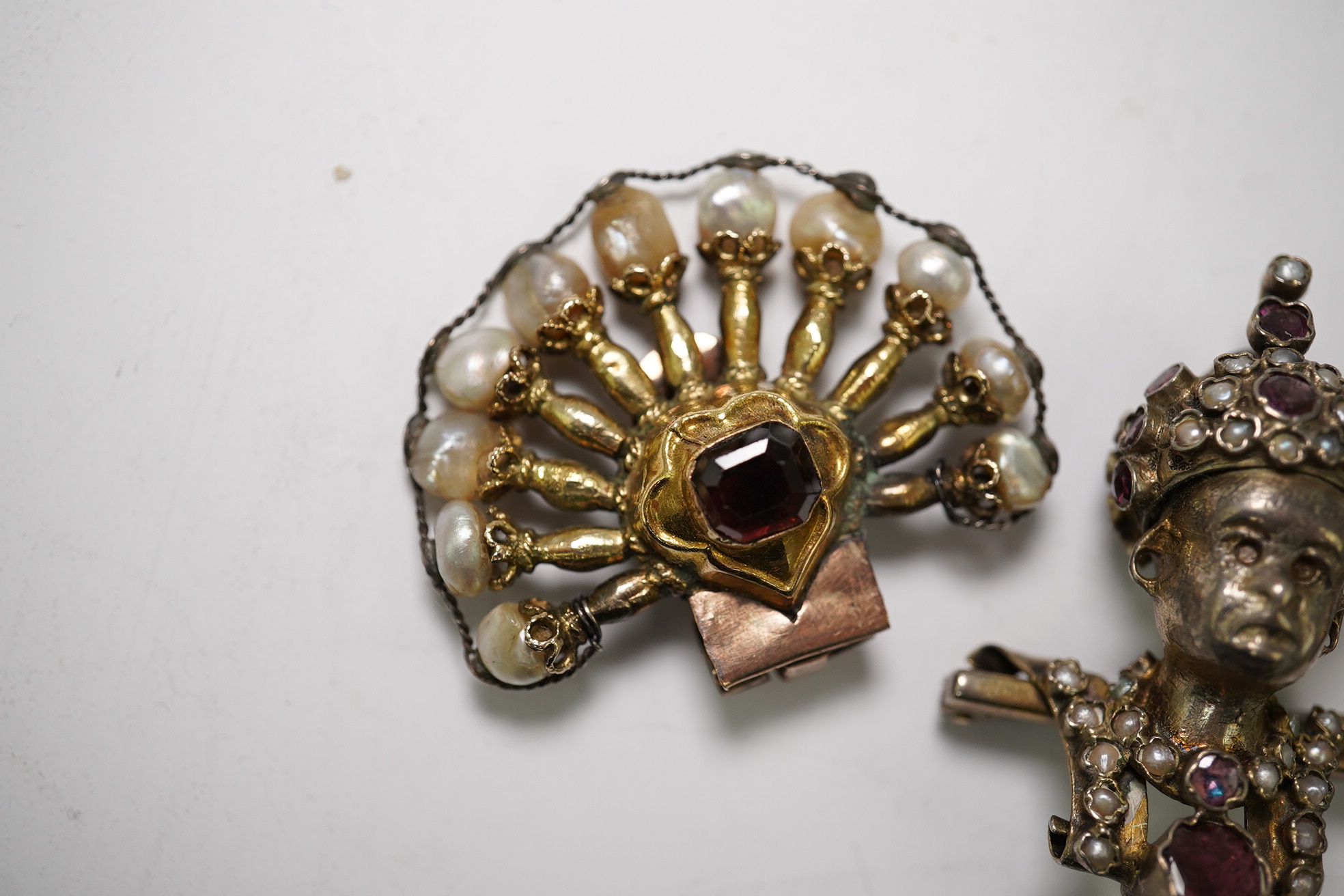 A pair of Indian ruby and baroque pearl set fan shaped ear clips, 42mm and a garnet and seed pearl set turbaned head brooch